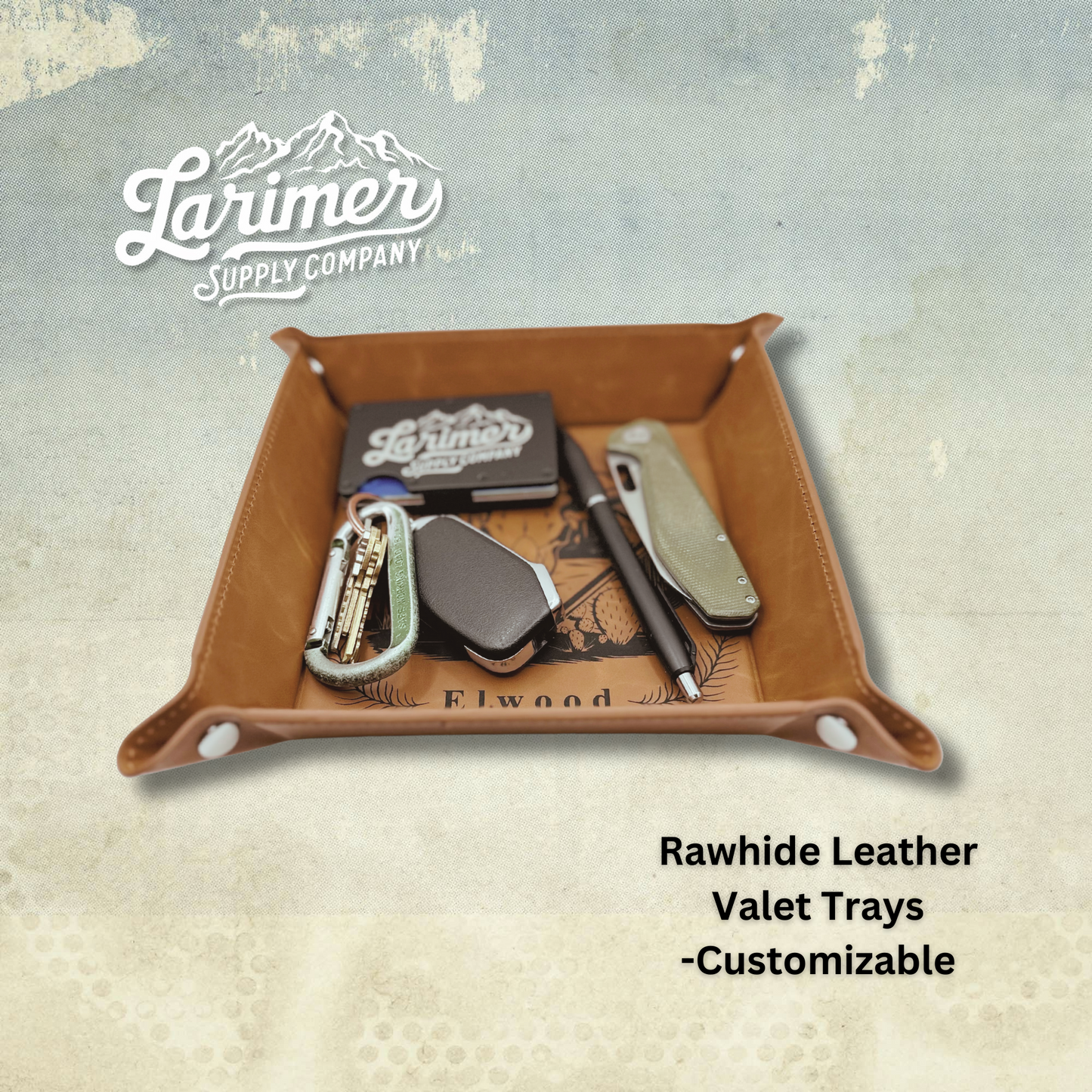 Leather valet tray with snap-button closures for holding wallet and keys, engraved with a custom design by Larimer Supply Company
